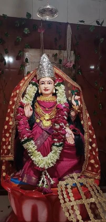 Colorful deity adorned in traditional attire with floral garlands.