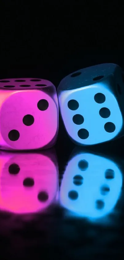 Neon pink and blue dice reflecting on a black surface.