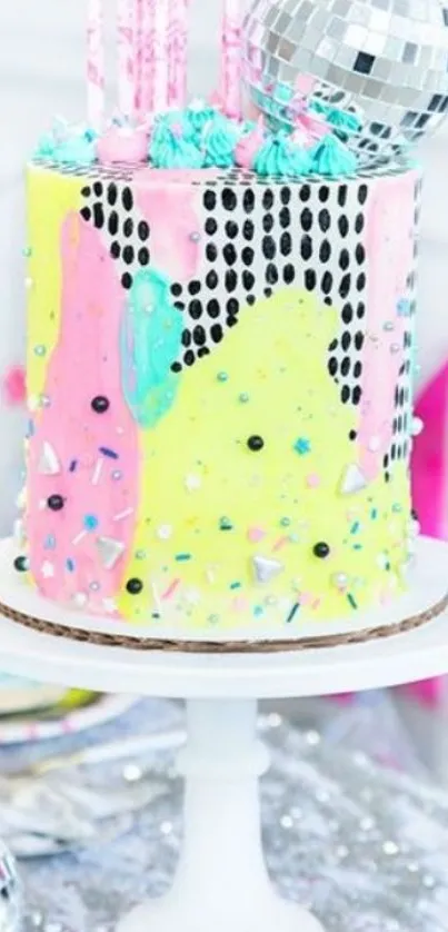 Vibrant cake with disco ball on white stand.