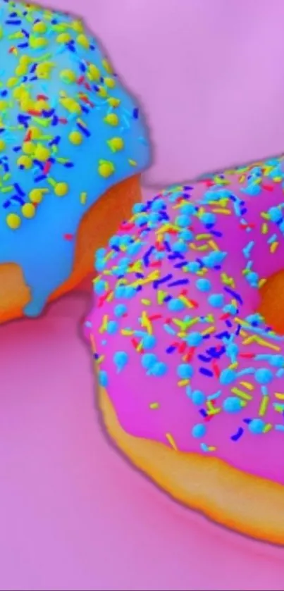 Two vibrant donuts with pink and blue frosting and colorful sprinkles.