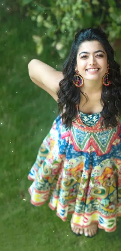 Woman in colorful dress smiling in a lush green garden.