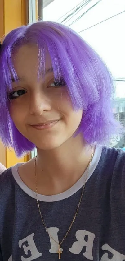 Smiling duo with vibrant purple hair in a colorful cafe setting.