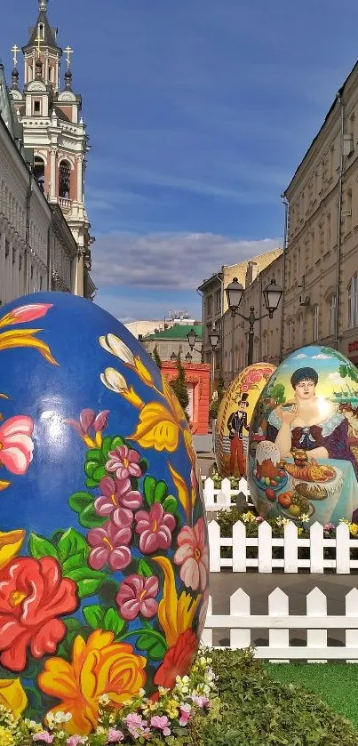 Colorful painted eggs on city street with historic architecture and blue sky.