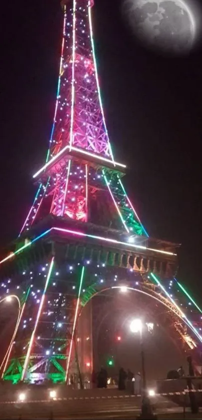 Eiffel Tower with vibrant neon lights under moonlight.