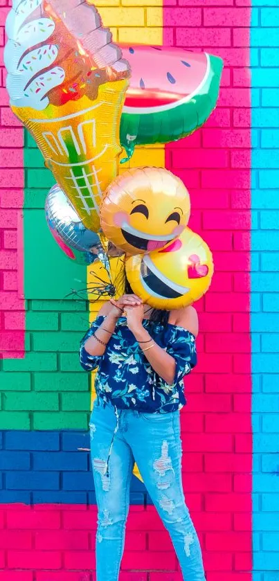 Bright emoji balloons against colorful brick wall background.