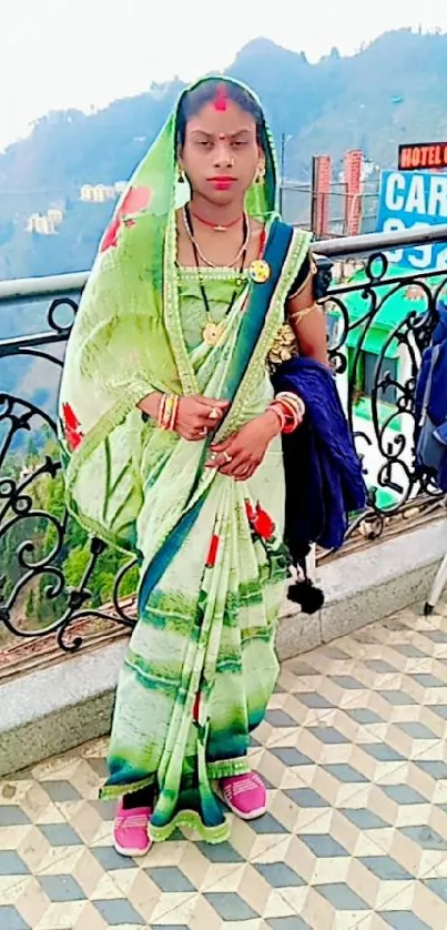 A woman in vibrant ethnic attire with mountain scenery.