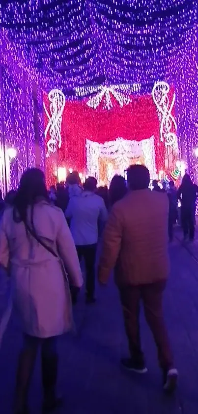 A crowd walks through vibrant purple festival lights at night.