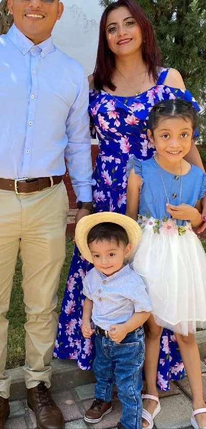 A happy family posing outdoors in colorful clothing.