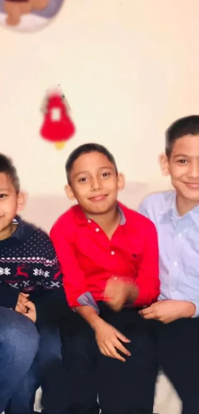 Three smiling children in bright clothes on a cozy couch.