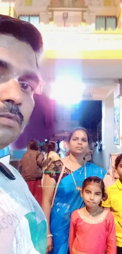 Family in traditional attire at temple during evening.