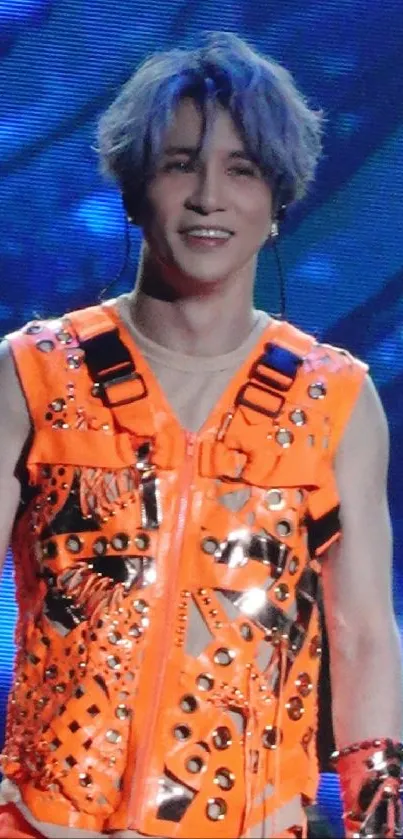 Person in a vibrant orange outfit on stage.