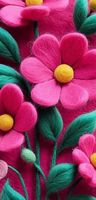 Vibrant felt flowers with green leaves on a pink background.