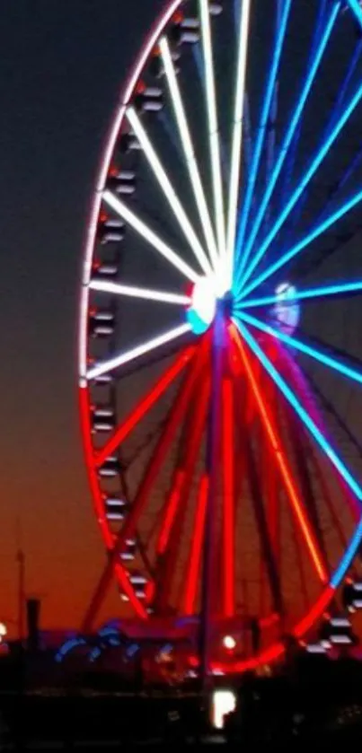 Vibrant Ferris wheel with red and blue lights at sunset.