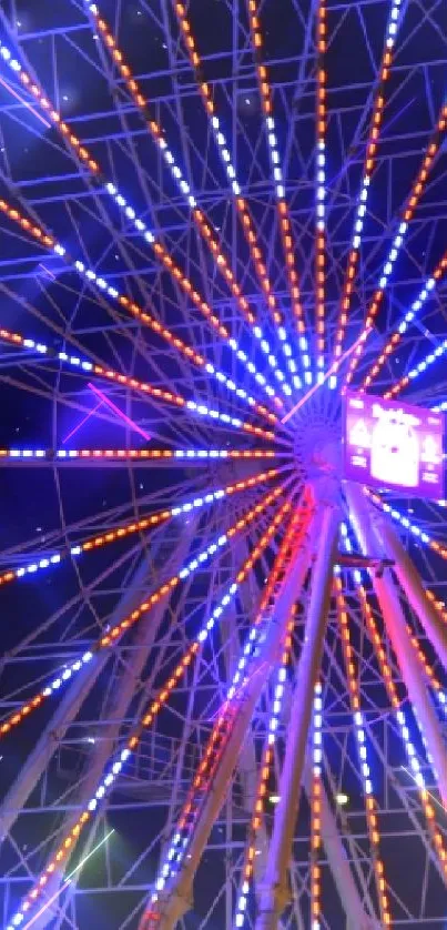 Ferris wheel with vibrant blue and orange lights at night.