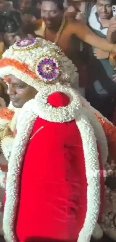 Person in traditional attire with vibrant garlands during a cultural festival celebration.