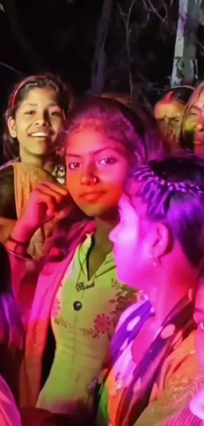 Vibrant crowd at a colorful festival with pink lighting and joyful expressions.