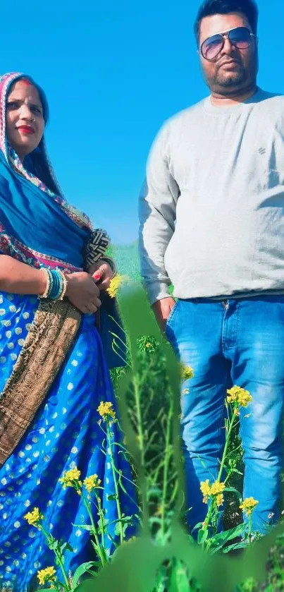 Couple in vibrant attire standing in a sunlit field.