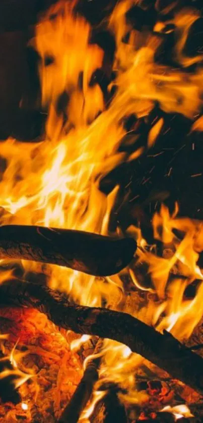 Mobile wallpaper of vibrant fire flames with burning logs and glowing embers.