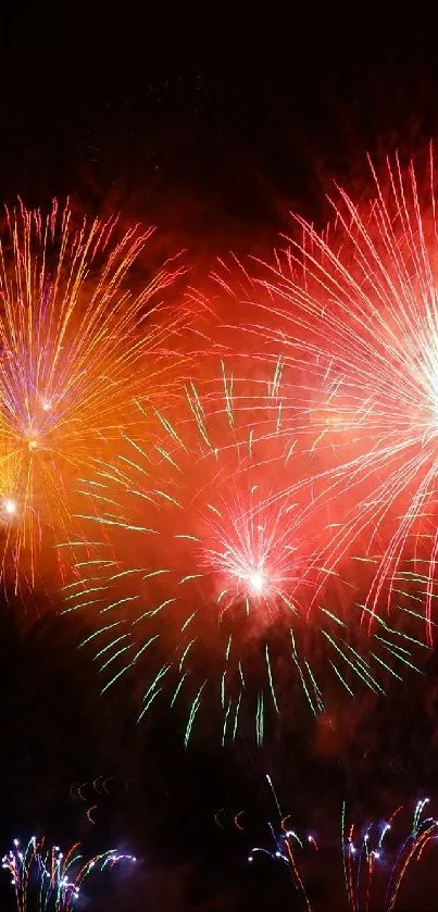 Bright red fireworks explode in the night sky, creating a vibrant display.