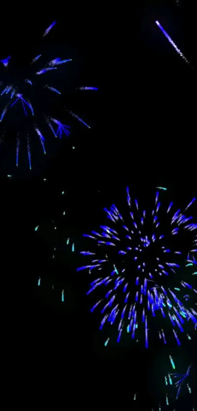 Vibrant blue and green fireworks against a black sky.