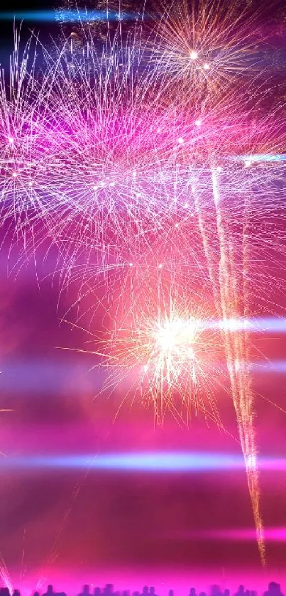 Vibrant fireworks lighting up the night sky with silhouettes of people.