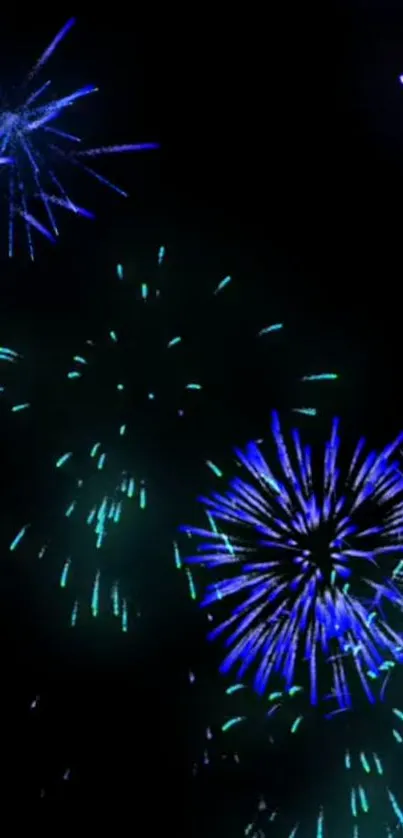 Vibrant fireworks display with blue and green bursts on a dark sky background.