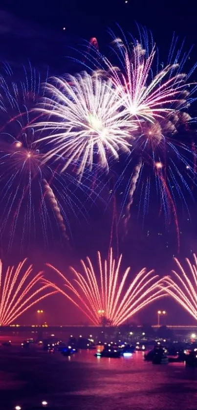 Colorful fireworks lighting up the night sky over a tranquil harbor.