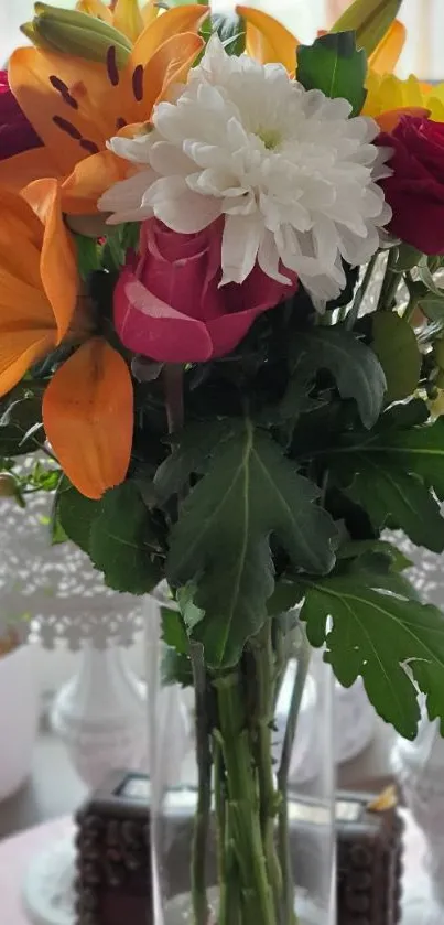 Vibrant bouquet of lilies, roses, and daisies in a clear vase.