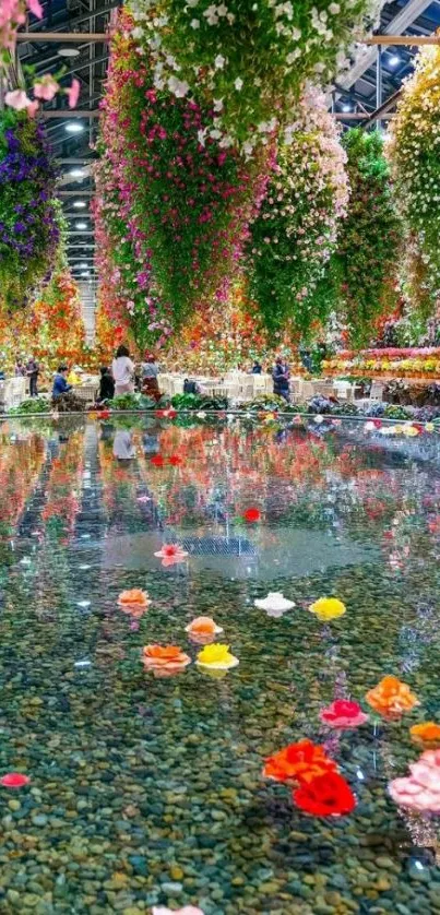 Vibrant hanging flowers reflecting on water in an indoor garden.