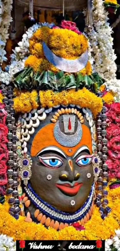 Floral adorned deity statue with vibrant colors and intricate design.