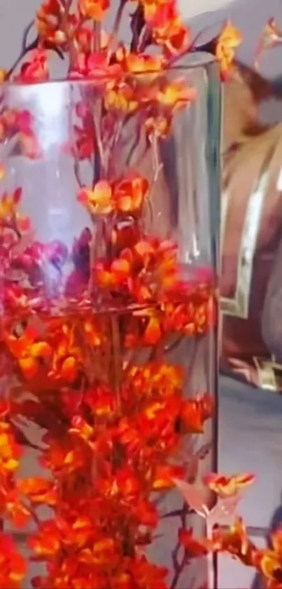 Vibrant orange flowers in clear glass vase.