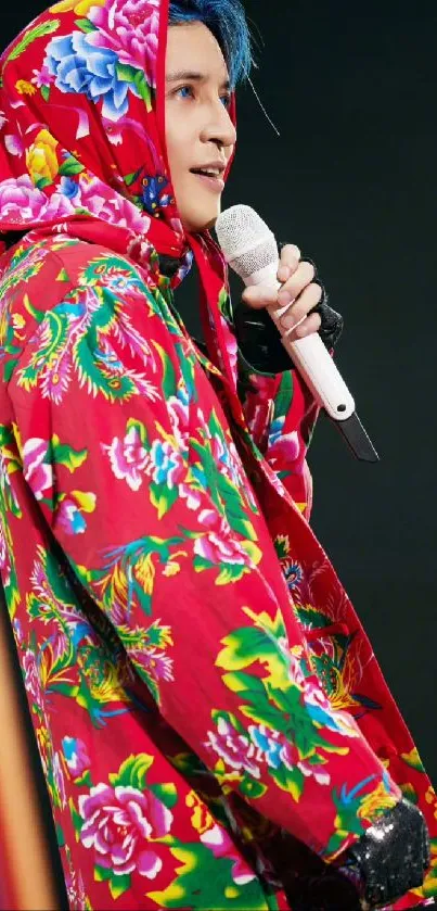 Stylish person in vibrant red floral hoodie on stage.