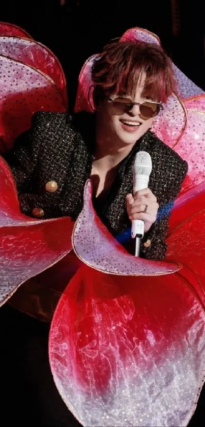 Performer with red petal costume on stage wallpaper.