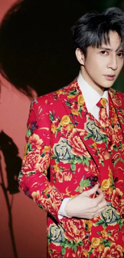 Stylish man in a vibrant floral suit under a dramatic shadow.