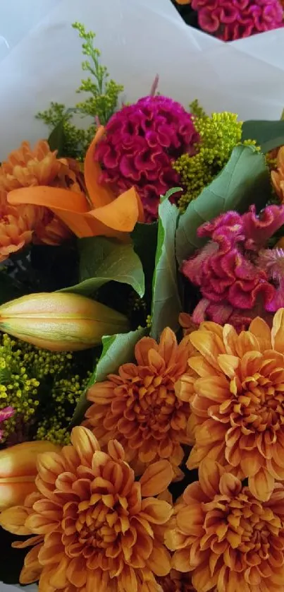 Vibrant orange and pink flower bouquet with green leaves.
