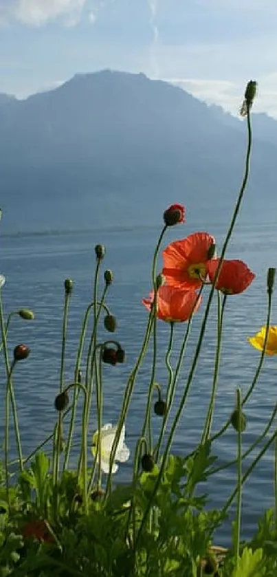 Vibrant flowers with a lake and mountain backdrop under a blue sky.