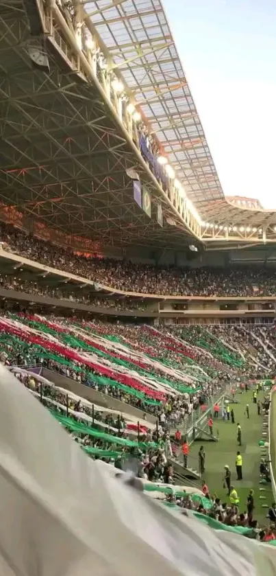 Vibrant football stadium with colorful banners and crowd cheering.