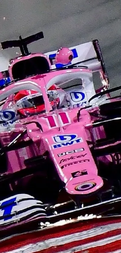 Vibrant pink Formula 1 race car speeding on track.