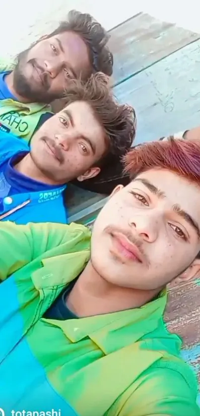 Group of friends taking a selfie in vibrant shirts outdoors.