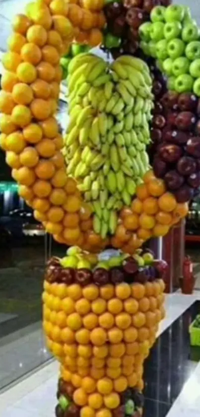 Artistic arrangement of oranges, bananas, and apples creating a vibrant fruit display.