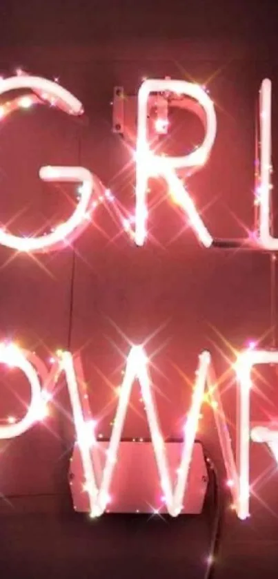 Neon 'GRL PWR' sign displaying pink glow on dark background.