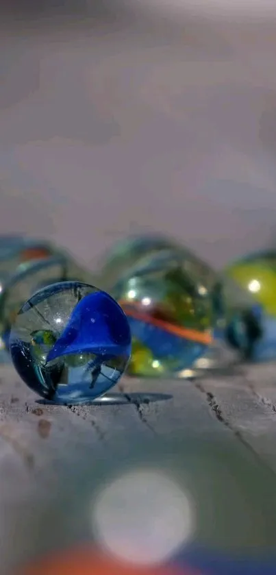 Colorful glass marbles on a wooden surface.