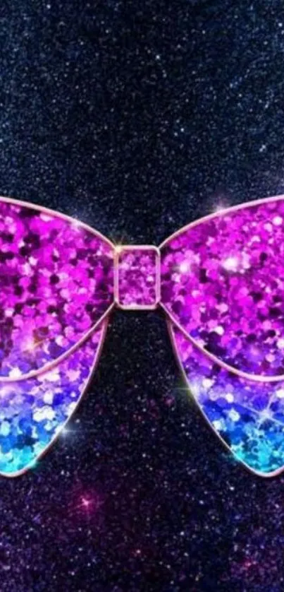 A glittery bow in pink and blue shades on a dark background.