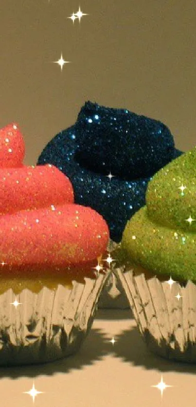 Three glittering cupcakes with pink, blue, and green frosting.