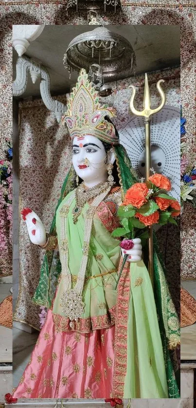 Goddess statue in colorful attire with a temple backdrop.