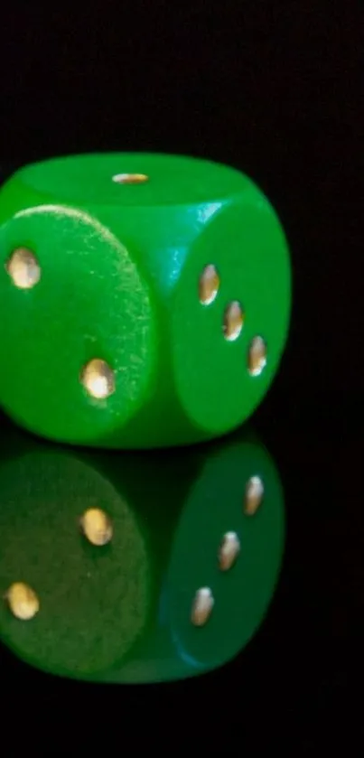 A green dice with reflection on a sleek black background.