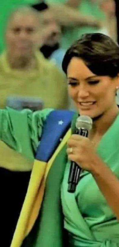 Person speaking at a vibrant public event, wearing green, surrounded by a crowd.