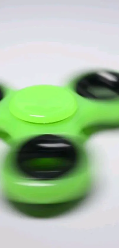 Vibrant green fidget spinner with motion blur effect.