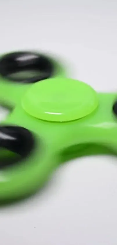 Bright green fidget spinner with black rings.