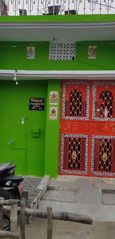 Vibrant green house with ornate red doors and traditional elements.